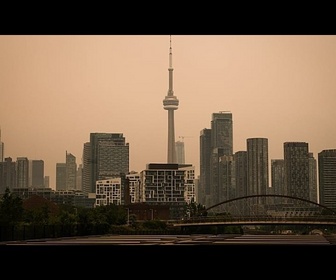 Replay À Toronto, la fumée des feux de forêt canadiennes teinte le ciel d'orange